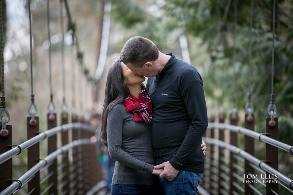 Elaina and Trip kiss on the suspension bridge during our Seattle area engagement photo session at the Bellevue Botanical Garden