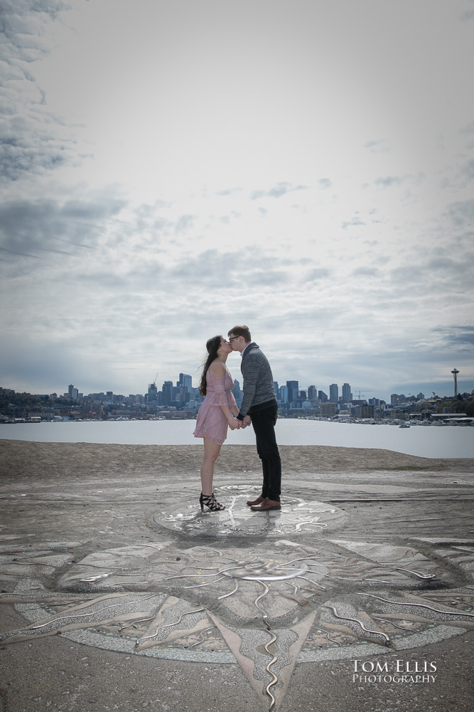 Yoshimi and Jake kiss on the top of the kite hill during their engagement photo session at Gas Works Park