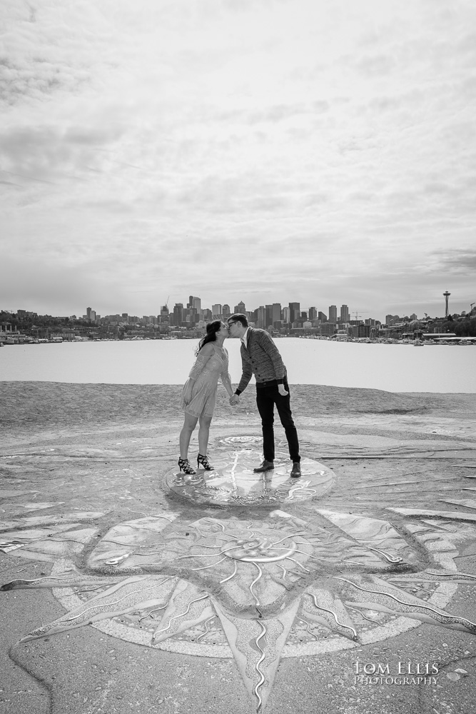 Yoshimi and Jake kiss on the sundial during their engagement photo session at Gas Works Park