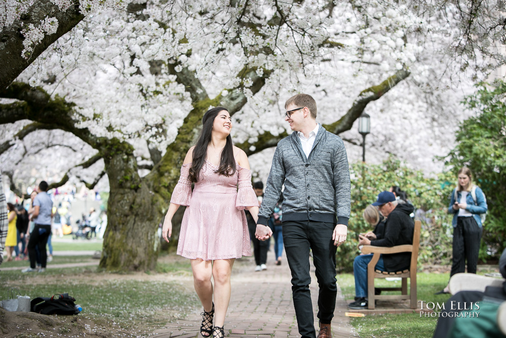 Yoshimi and Jake in the middle of the cherry trees during their engagement photo session at the UW campus