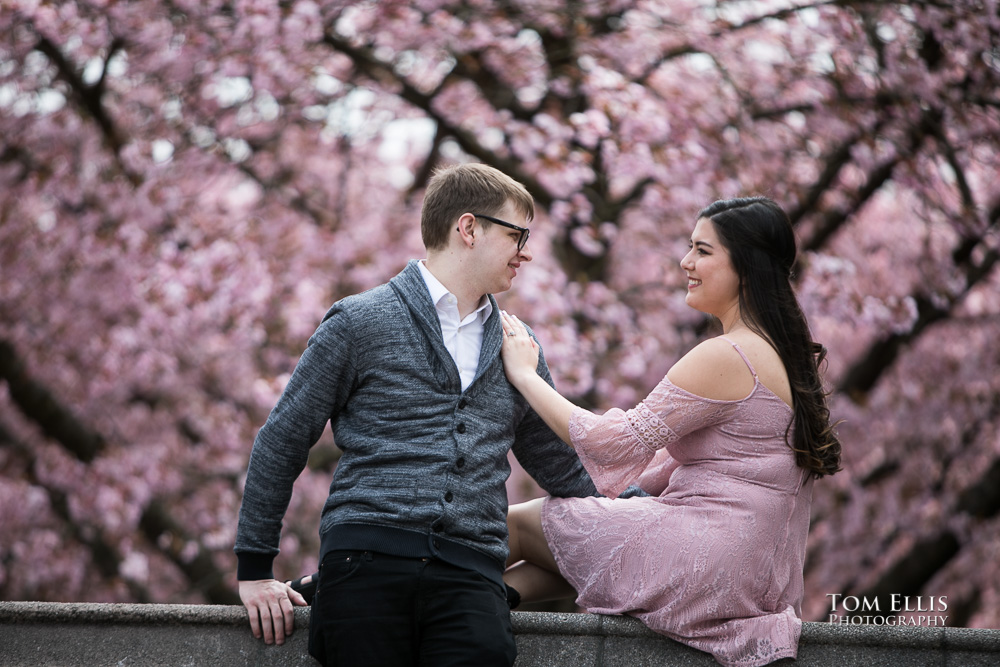 Yoshimi and Jake with the pink cherry trees during their engagement photo session at the UW campus