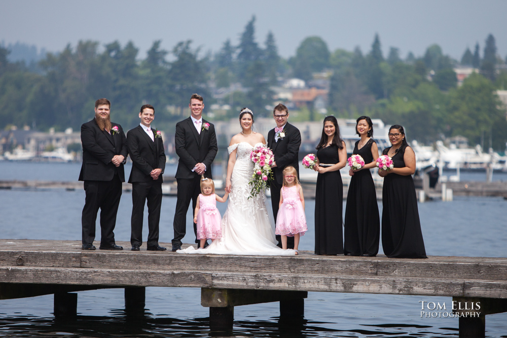 Entire wedding party of bride, groom, bridesmaids, groomsmen and flower girls pose on a dock for a group photo at this Seattle area wedding. Tom Ellis Photography, Seattle weding photographerd