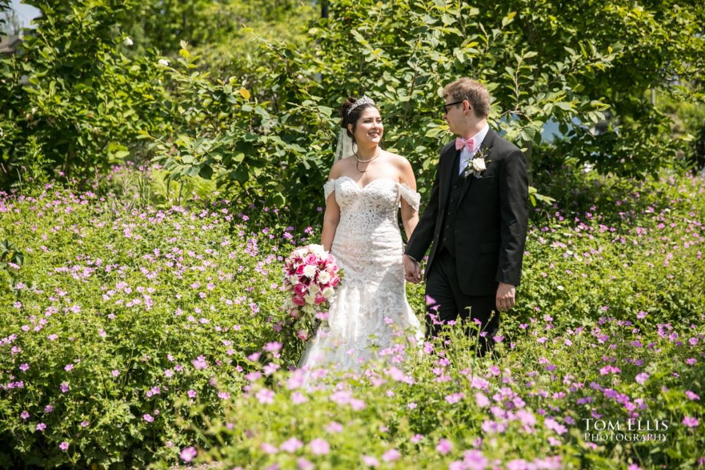 Bride and groom stroll through a beautiful garden during their pre-ceremony photo session. Tom Ellis Photography
