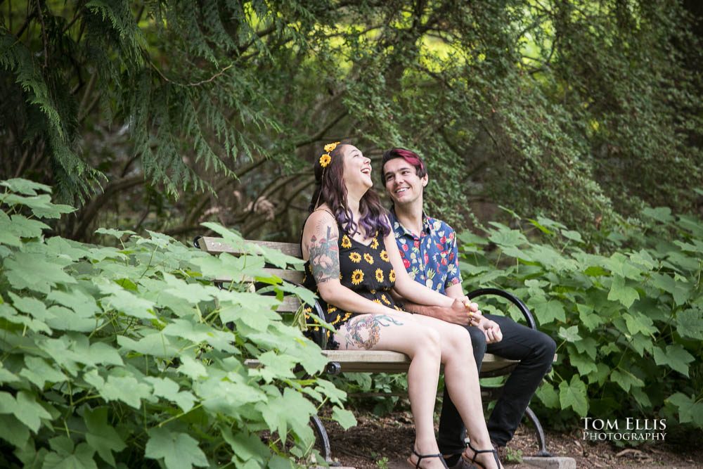 Aimee and Jordan take a break on a bench during their Seattle engagement photo session at the Washington Arboretum