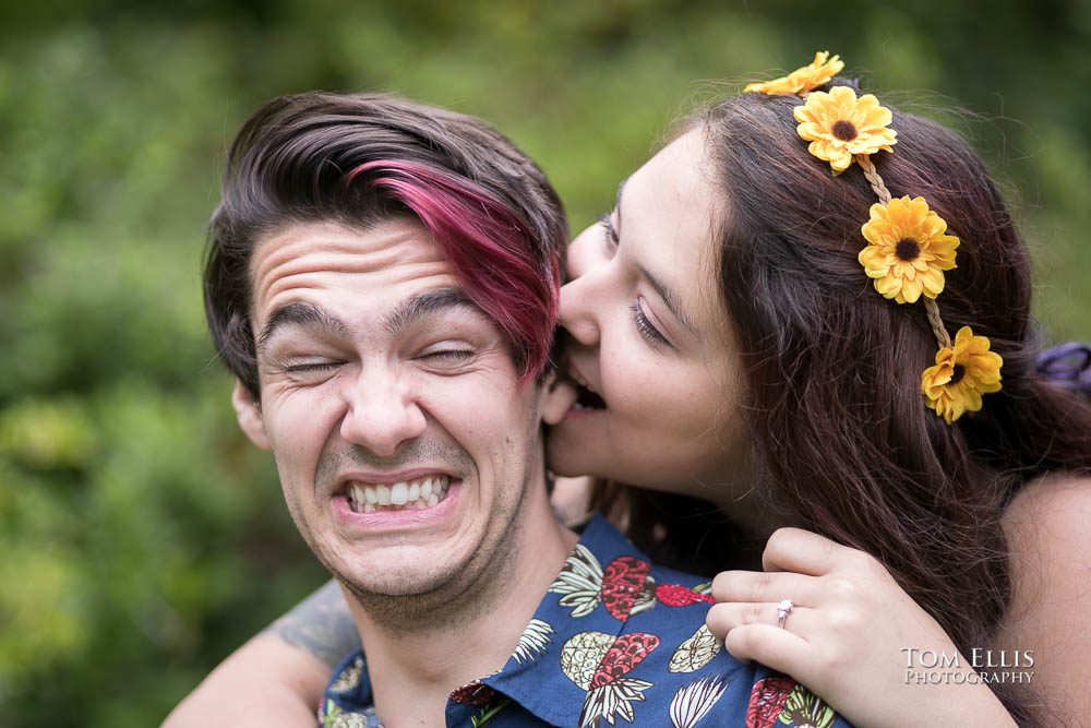 Close up of Aimee biting Jordan's ear during their Seattle engagement photo session at the Washington Arboretum