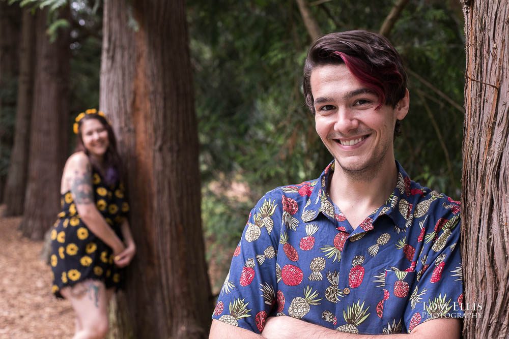 Close up of Jordan with Aimee in the background during their Seattle engagement photo session at the Washington Arboretum