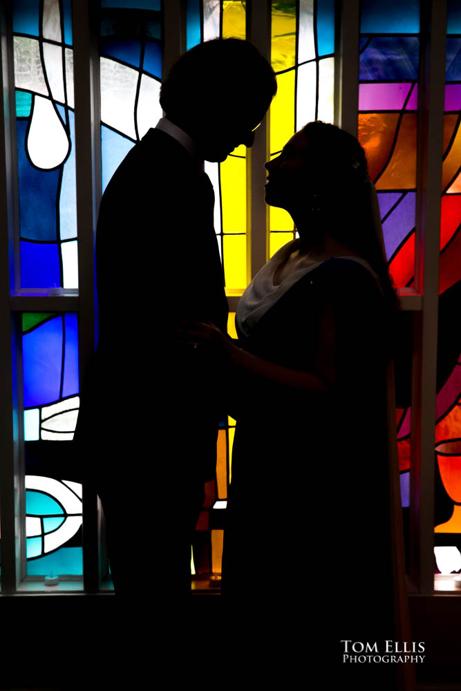 Bride and groom silhouette against stained glass windows.  Fantastic fantasy and science fiction HTTYD wedding - Tom Ellis Photography, Seattle wedding photographer