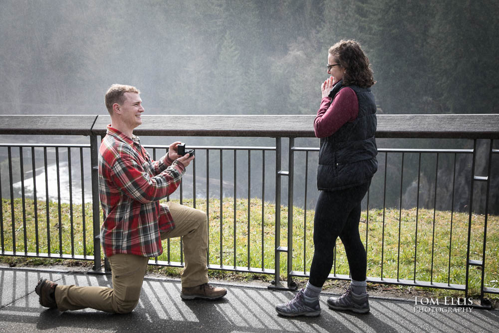 Ben proposes to Samantha, while Snoqualmie Falls in the background covers them with mist. Tom Ellis Photography, destination engagement photographer