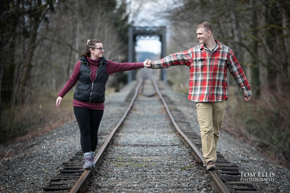 Snoqualmie Falls surprise proposal and engagement session - Ben and Sammy balance on the railroad tracks