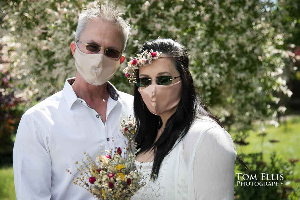 Liliana and Greg pose for a photo, complete with masks, after their wedding that was held inside their car. Tom Ellis Photography, Seattle wedding photographer