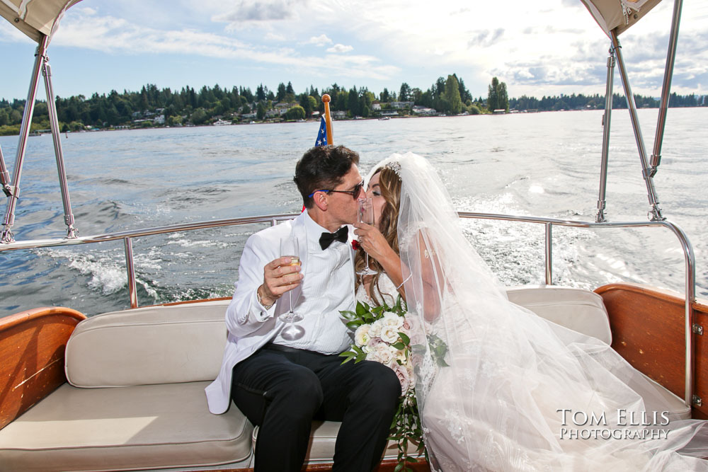 Alan and Zena enjoy a ride in a classic boat during their wedding reception at the Woodmark Hotel. Tom Ellis Photography, Seattle wedding photographer