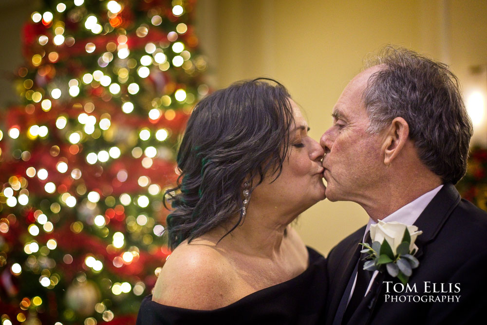 Susan and Tom kiss in front of a Christmas tree during their Holiday wedding at the Seattle Tennis Club. Tom Ellis Photography, Seattle weddng photographer