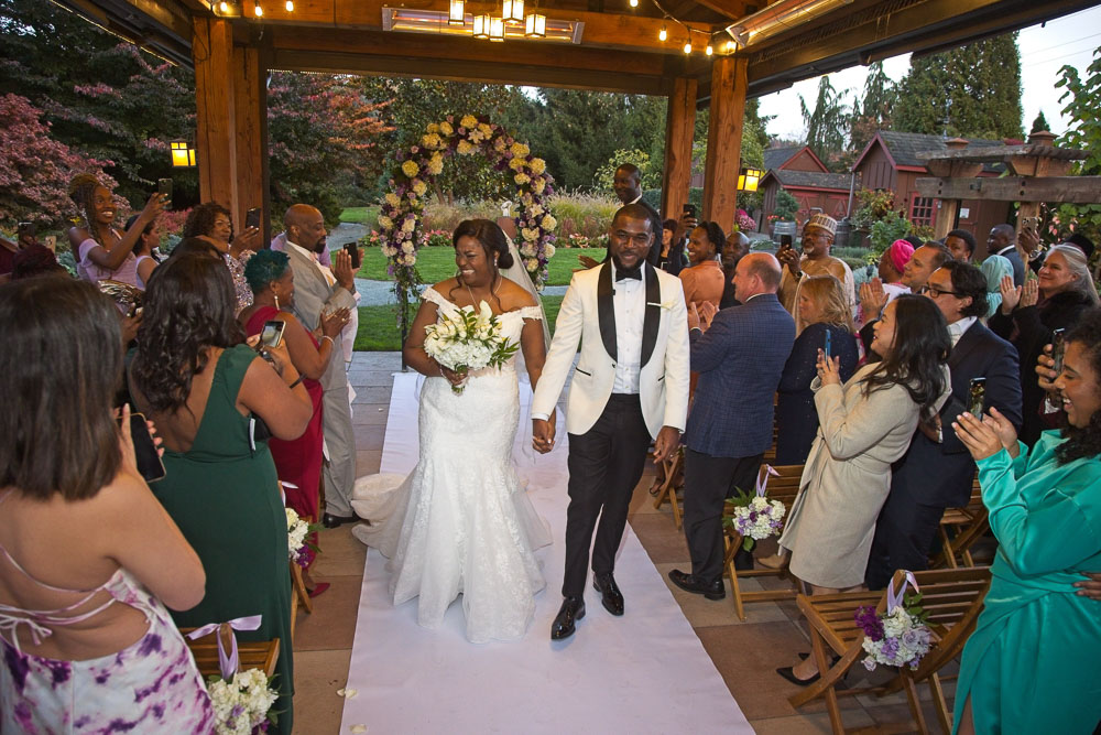 Sue and Shanun come down the aisle at the conclusion of their wedding ceremony at the Willows Lodge. Tom Ellis Photography, Seattle wedding photography.