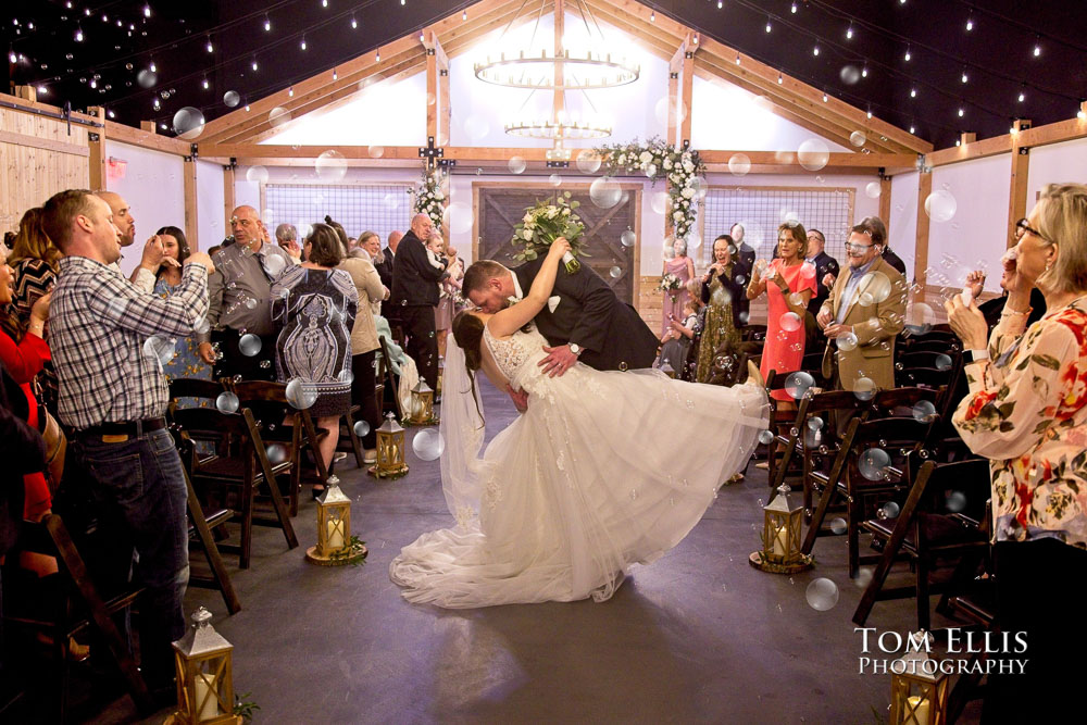 Jennifer and Jay stop for a kiss while walking down the aisle at the conclusion of their wedding ceremony at Liljebeck Farms.